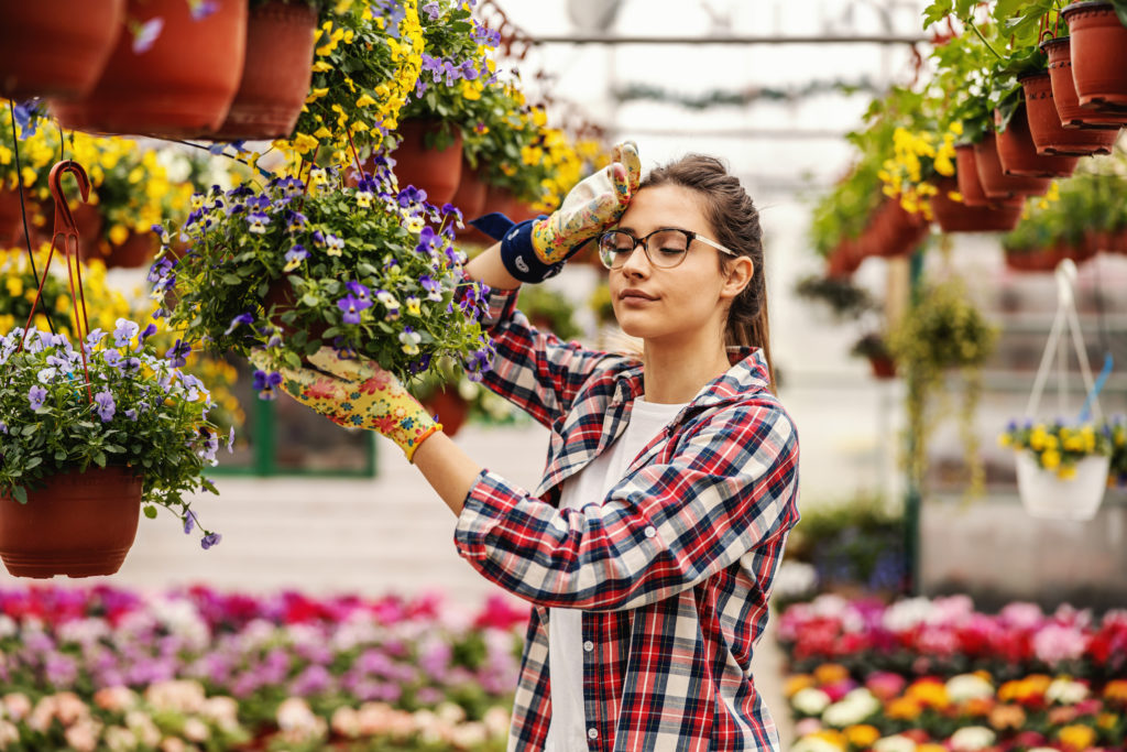 Young hardworking female nursery garden worker